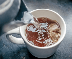 25 Pouring boiling water in to a mug containing a one-cup teabag whilst making a drink of English tea