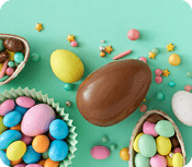 Easter sweets concept. Top view photo of easter bunny ears chocolate eggs with dragees and sprinkles on turquoise background with empty space