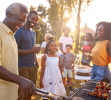 Multi generation black family barbecue, grandad grilling