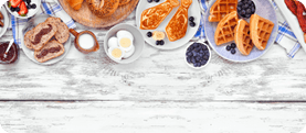 Fathers Day brunch top border. Above view on a white wood banner background. Tie pancakes, mustache toast and a variety of dad themed food.