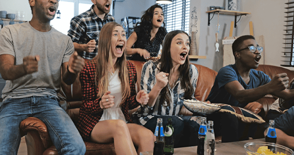 African American sports fans celebrate win at home. Passionate supporters shout crazy watching game on TV. 4K slow motion. Close up. Euphoria. World Championship. Excited and emotional. Entertainment.