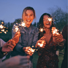 Group of friends enjoying out with sparklers  Young men and women enjoying with fireworks 