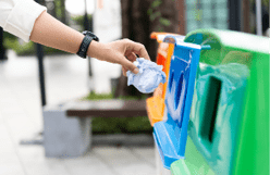 Closeup portrait woman hand throwing crumpled paper in recycling bin.