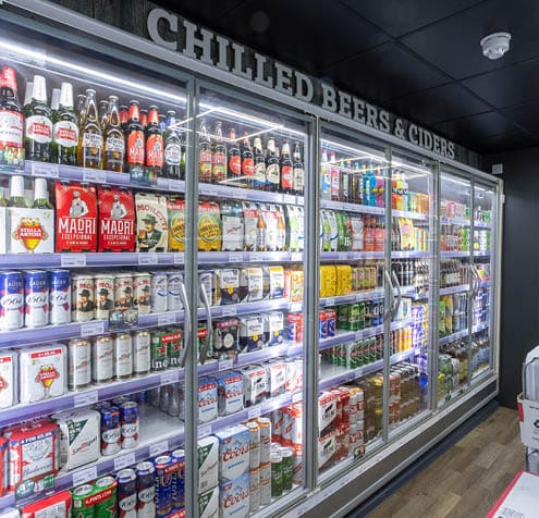 A refrigerator with a lot of beer in it. Description generated by AI