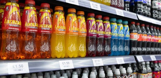 A store shelf with many different flavored drinks. Description generated by AI