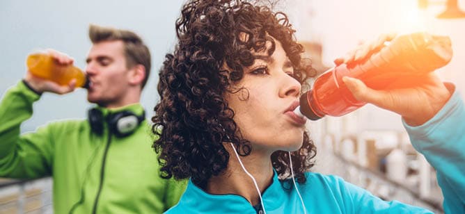 A woman drinking a red beverage. Description generated by AI