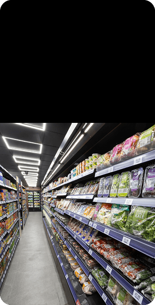 A grocery store with a blue floor and shelves full of food. Description generated by AI