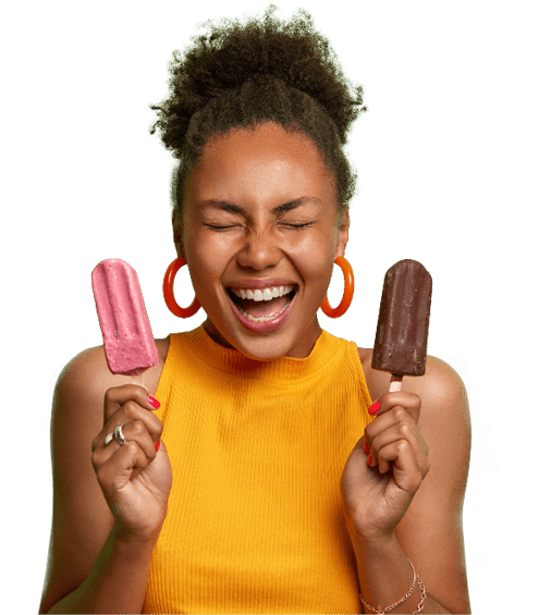 A woman with a yellow shirt holding two chocolate and pink frozen treats. Description generated by AI