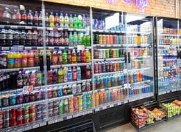 A store with a cooler full of soda. Description generated by AI