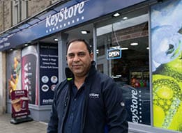 A man standing in front of a store. Description generated by AI
