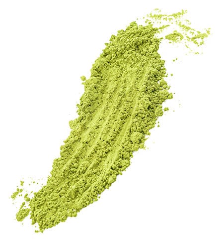 A green powder on a white background. Description generated by AI