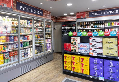 A store with a cooler and a refrigerator full of beer and soda. Description generated by AI