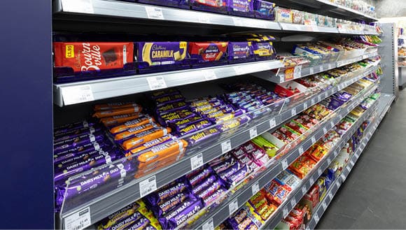 A store with a variety of candy and chocolate bars. Description generated by AI