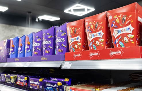 A display of chocolates and candy bars. Description generated by AI