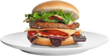 A sandwich with lettuce, tomato, cheese, bacon, and a beef patty is served on a white plate. Description generated by AI