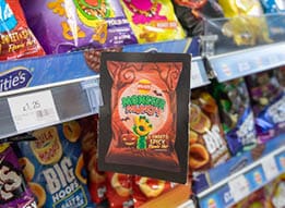 A shelf in a store displays various colorful snack bags with a prominent sign showing a price of £1.25. Description generated by AI