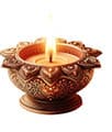A lit decorative oil lamp with intricate floral and heart-shaped patterns carved into its bronze-colored metal surface. Description generated by AI